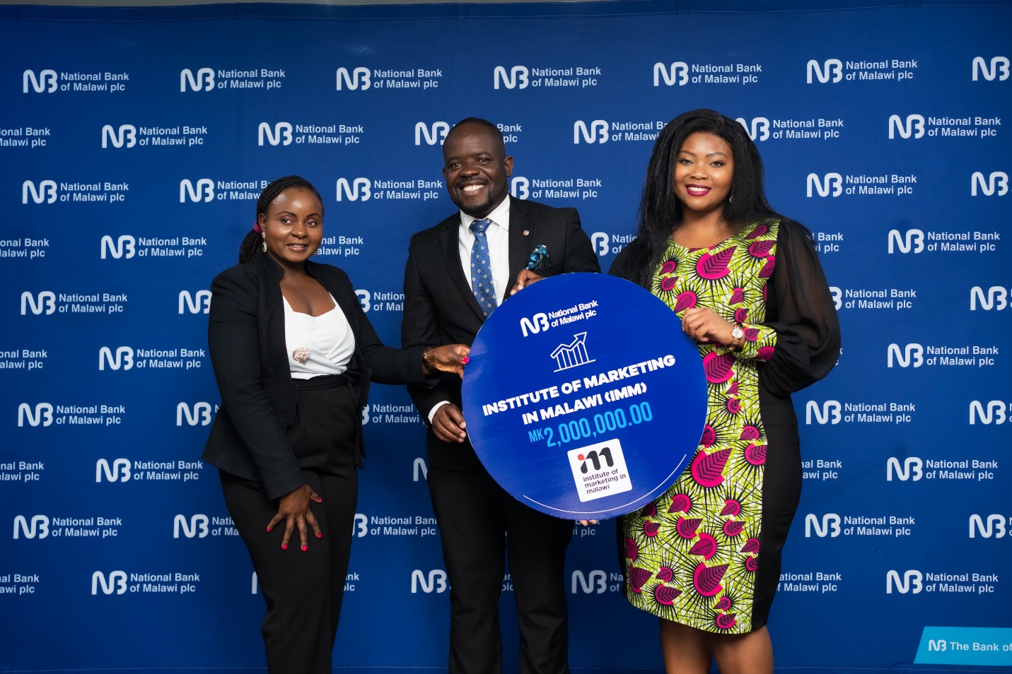 Akossa Hiwa (far right), Marketing and Corporate Affairs Manager presenting a dummy cheque to George Damsom (middle), the IMM Conference Chairperson.