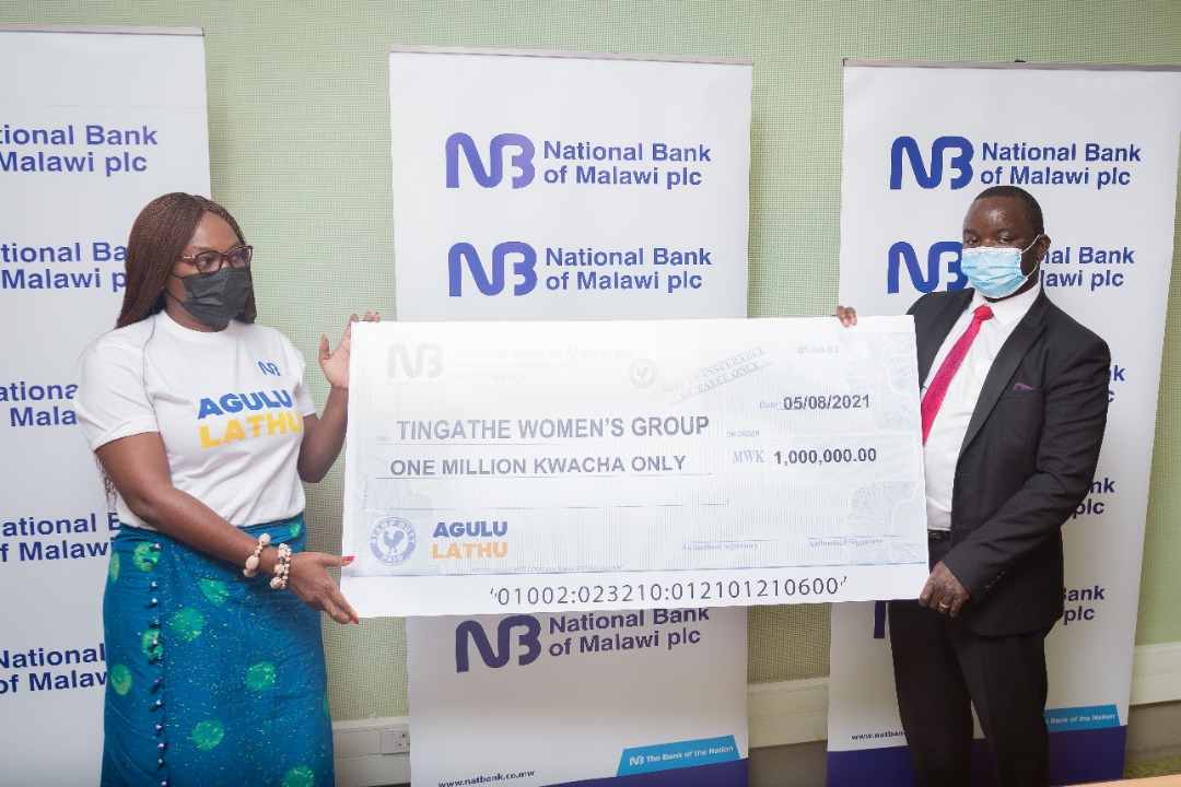 Chomanda (L) receives a dummy cheque from Chijere