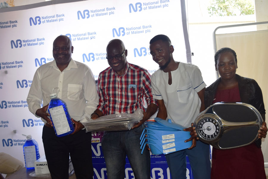 Kawawa second left and NBM Head of Retail Banking Division Oswin Kasunda left with some of the donated medical equipment