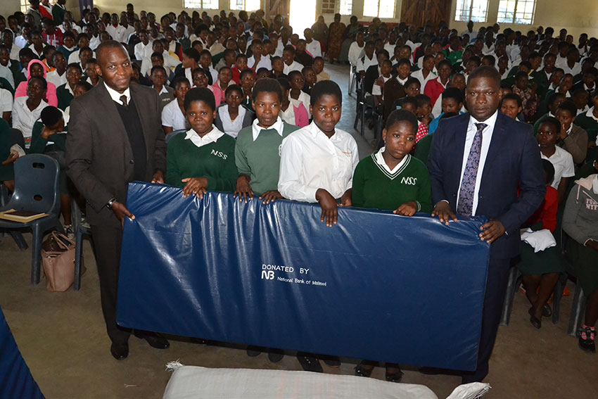 Jiya (right) and NBM Head of Cards & eBanking William Kaunda (left) making a symbolic presentation of the matteresses